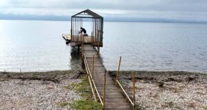 Σε ιδιαίτερα υψηλούς τόνους τοποθετείται το Δίκτυο Ενεργών Πολιτών με ανακοίνωσή του σχετικά με την υπόθεση της εξέδρας που είχε τοποθετηθεί στη λίμνη Τριχωνίδα, στη θέση Δογρή, κάνοντας λόγο για παράνομη εγκατάσταση και αυθαίρετη κατάληψη χώρου όχθης. Όπως αναφέρεται, κατά τη συνεδρίαση του Δημοτικού Συμβουλίου της 27ης Απριλίου 2026, στο πλαίσιο της συζήτησης για το οικοσύστημα των λιμνών Τριχωνίδας – Λυσιμαχίας, τέθηκε εκ νέου το ζήτημα της συγκεκριμένης εξέδρας, η οποία – σύμφωνα με το Δίκτυο – κρίθηκε παράνομη έπειτα από αυτοψία των αρμόδιων υπηρεσιών, και συγκεκριμένα της Κτηματικής Υπηρεσίας Αιτωλοακαρνανίας και της αρμόδιας Διεύθυνσης της Περιφέρειας Δυτικής Ελλάδας. Το Δίκτυο υποστηρίζει ότι πρόκειται για κατασκευή χωρίς άδεια, που συνιστά αυθαίρετη κατάληψη χώρου όχθης, όπως αυτή οριοθετείται με βάση το σχετικό ΦΕΚ (703/Δ/29/06/2005), ενώ στρέφεται ευθέως κατά του επικεφαλής της μείζονος αντιπολίτευσης, Κώστα Πιστιόλα, αποδίδοντάς του ευθύνη για την εγκατάσταση. Παράλληλα, στην ανακοίνωση γίνεται λόγος για προσπάθεια αμφισβήτησης των πορισμάτων των αρμόδιων υπηρεσιών, με το Δίκτυο να κατηγορεί τον κ. Πιστιόλα ότι παρουσίασε τη συγκεκριμένη εγκατάσταση ως νόμιμη, διατυπώνοντας – όπως αναφέρεται – ψευδείς ισχυρισμούς κατά τη διάρκεια της συνεδρίασης. Σε έντονο ύφος, γίνεται επίσης λόγος για απαράδεκτη στάση και για απειλές που εκτοξεύθηκαν προς διάφορες κατευθύνσεις, με αφορμή την ανάδειξη του ζητήματος τόσο εντός του Δημοτικού Συμβουλίου όσο και από μέσα ενημέρωσης. Προς ενίσχυση των θέσεών του, το Δίκτυο Ενεργών Πολιτών παραθέτει συγκεκριμένα έγγραφα, μεταξύ των οποίων το υπ’ αριθ. πρωτ. 12594/04-02-2026 της Κτηματικής Υπηρεσίας Αιτωλοακαρνανίας, καθώς και την από 12/01/2026 προσωρινή έκθεση ελέγχου της Διεύθυνσης Περιβάλλοντος της Περιφέρειας Δυτικής Ελλάδας. Η ανακοίνωση υπογράφεται από την Κωνσταντία Τραμπάζαλη, εκπρόσωπο του Δικτύου Ενεργών Πολιτών.